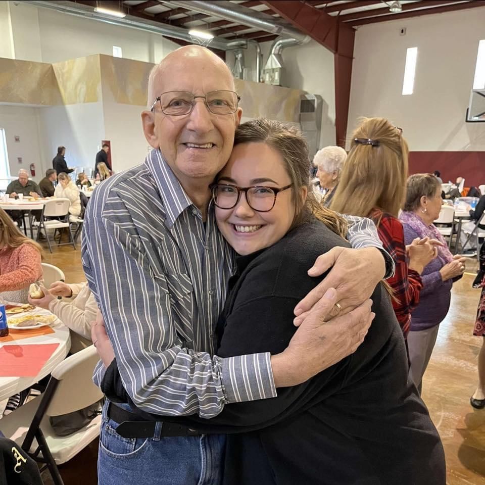 A man and a woman are hugging each other in a room.