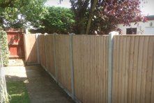 A wooden fence with concrete fence posts