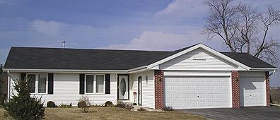 White ranch home with black shutters and a two-car garage on a sunny day.