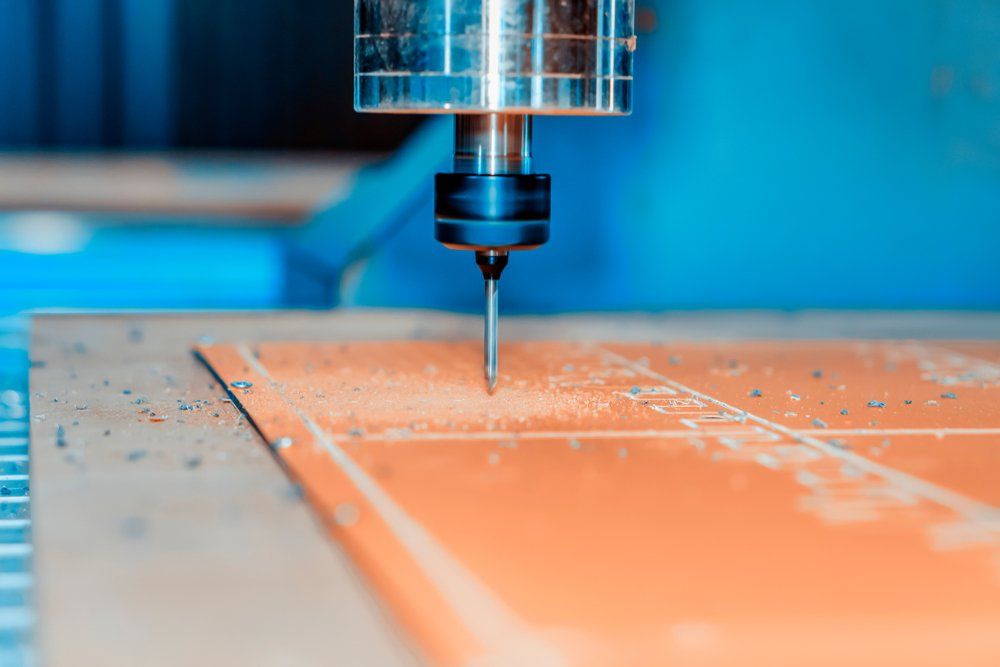 Eine Maschine schneidet ein Stück Holz auf einem Tisch.