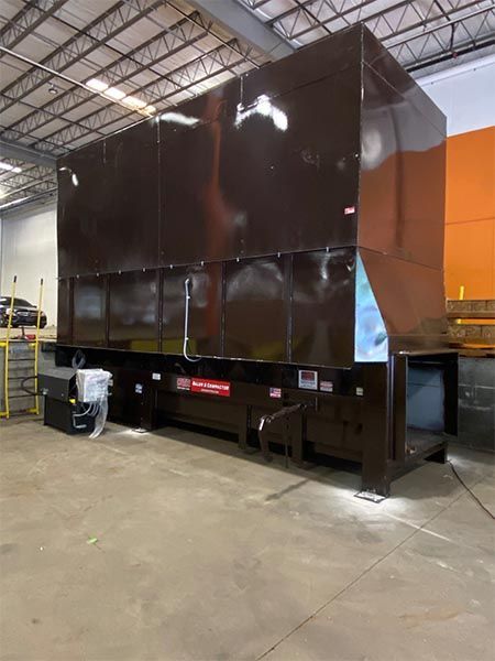 Large brown industrial machine inside a warehouse.
