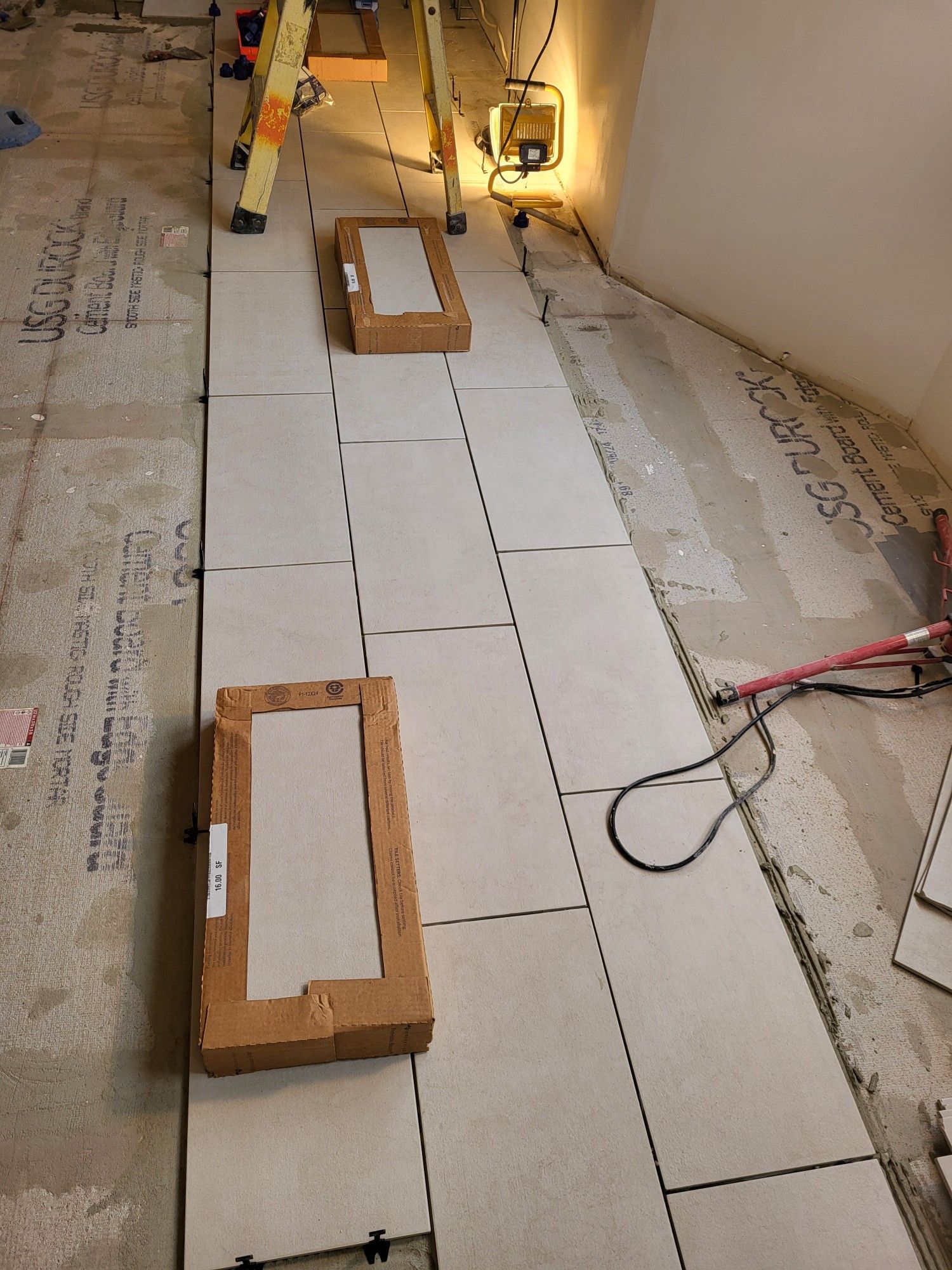 A row of tiles are being installed on a floor.