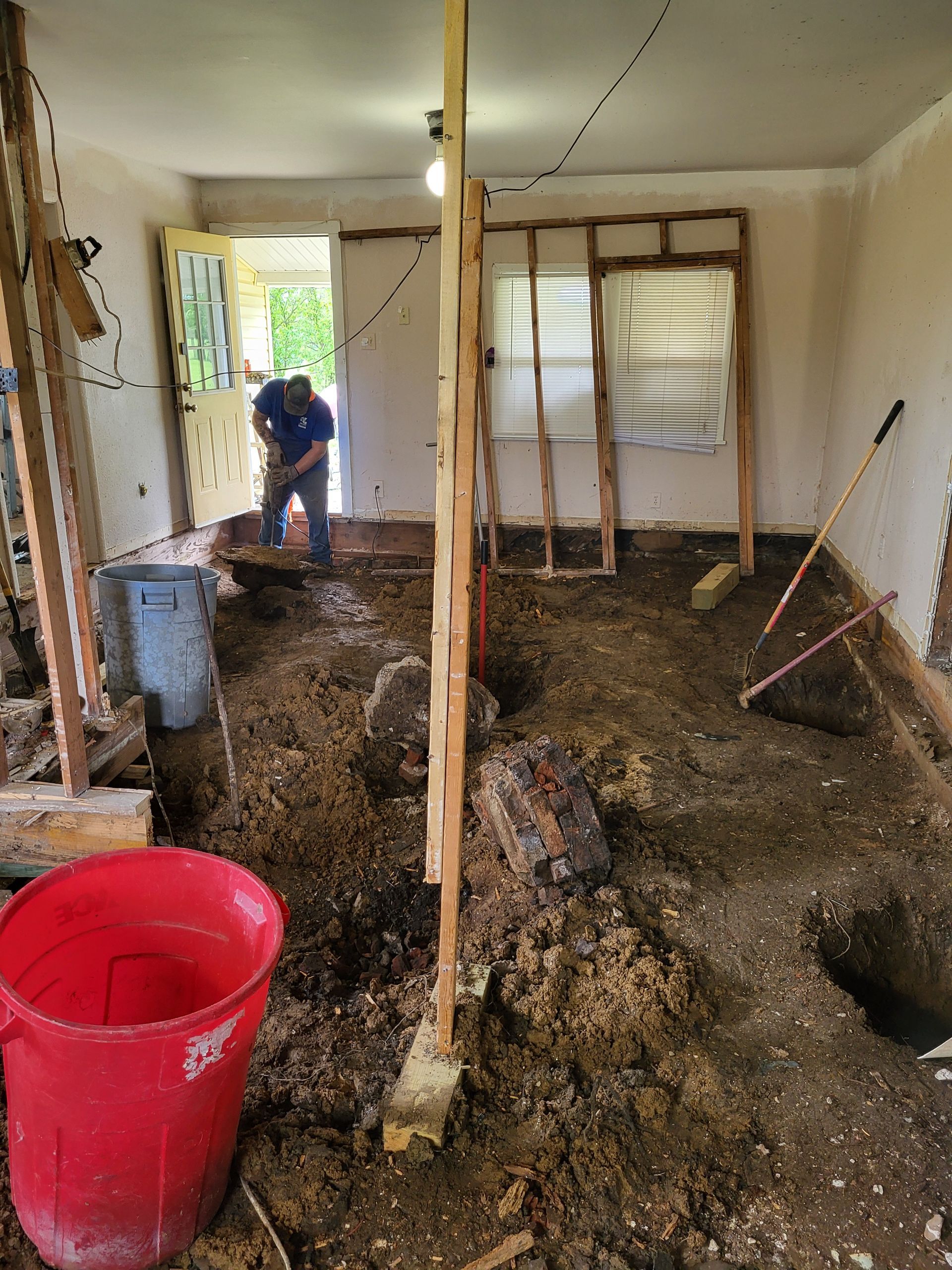 A man is digging in the dirt in a room.