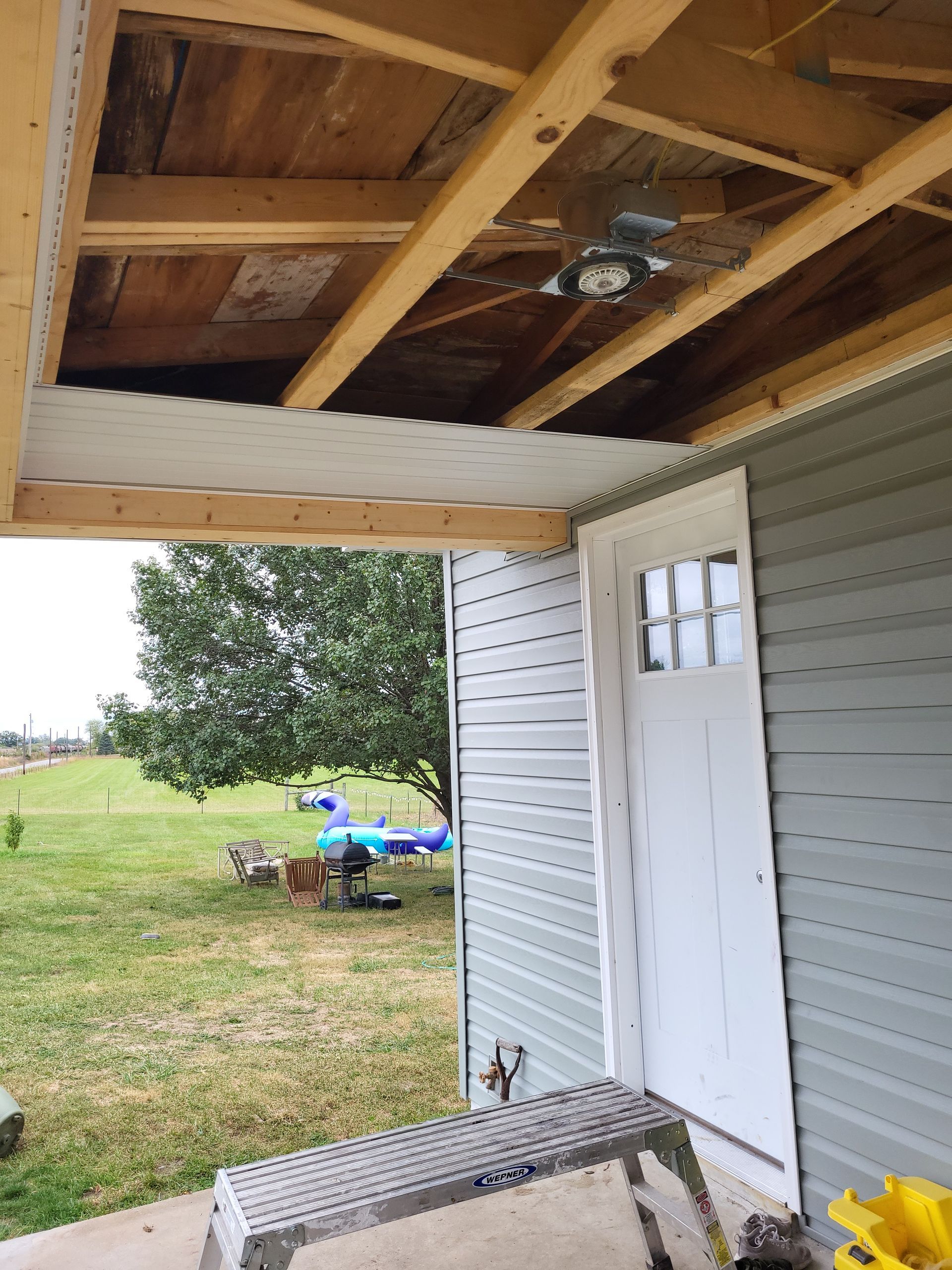 A ceiling fan is hanging from the roof of a house.