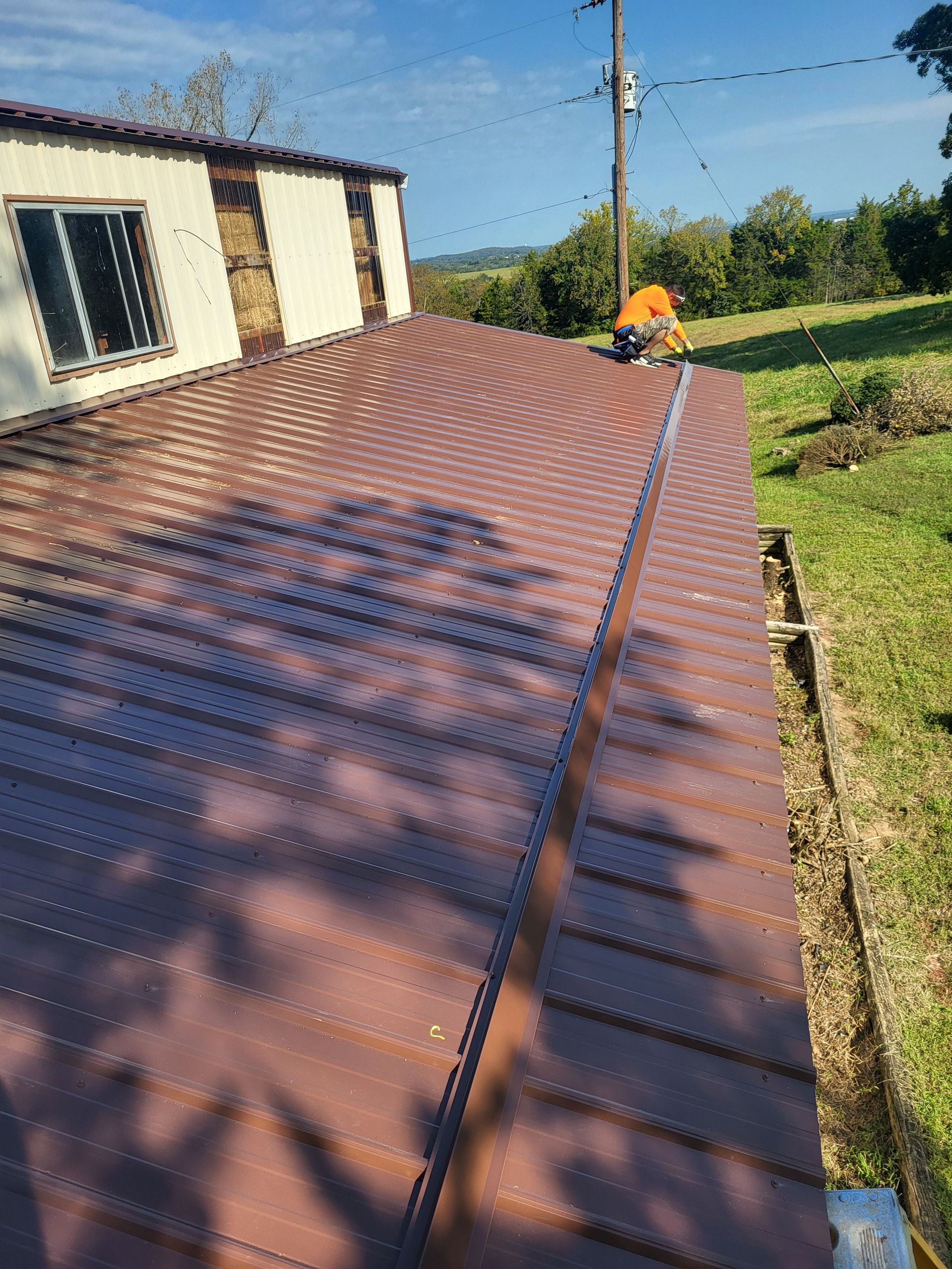 A man is working on the roof of a house.