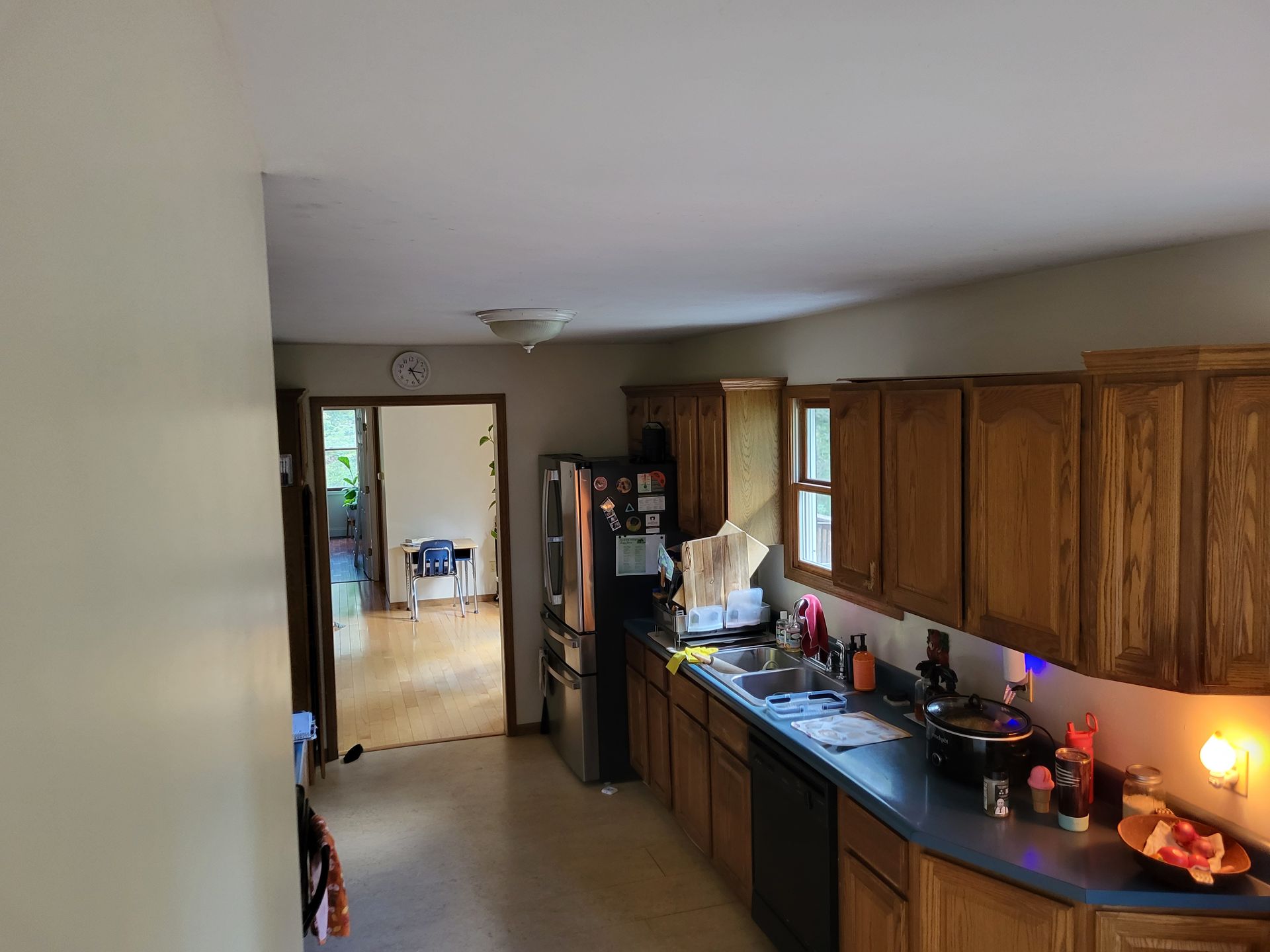 A kitchen with wooden cabinets and a black refrigerator