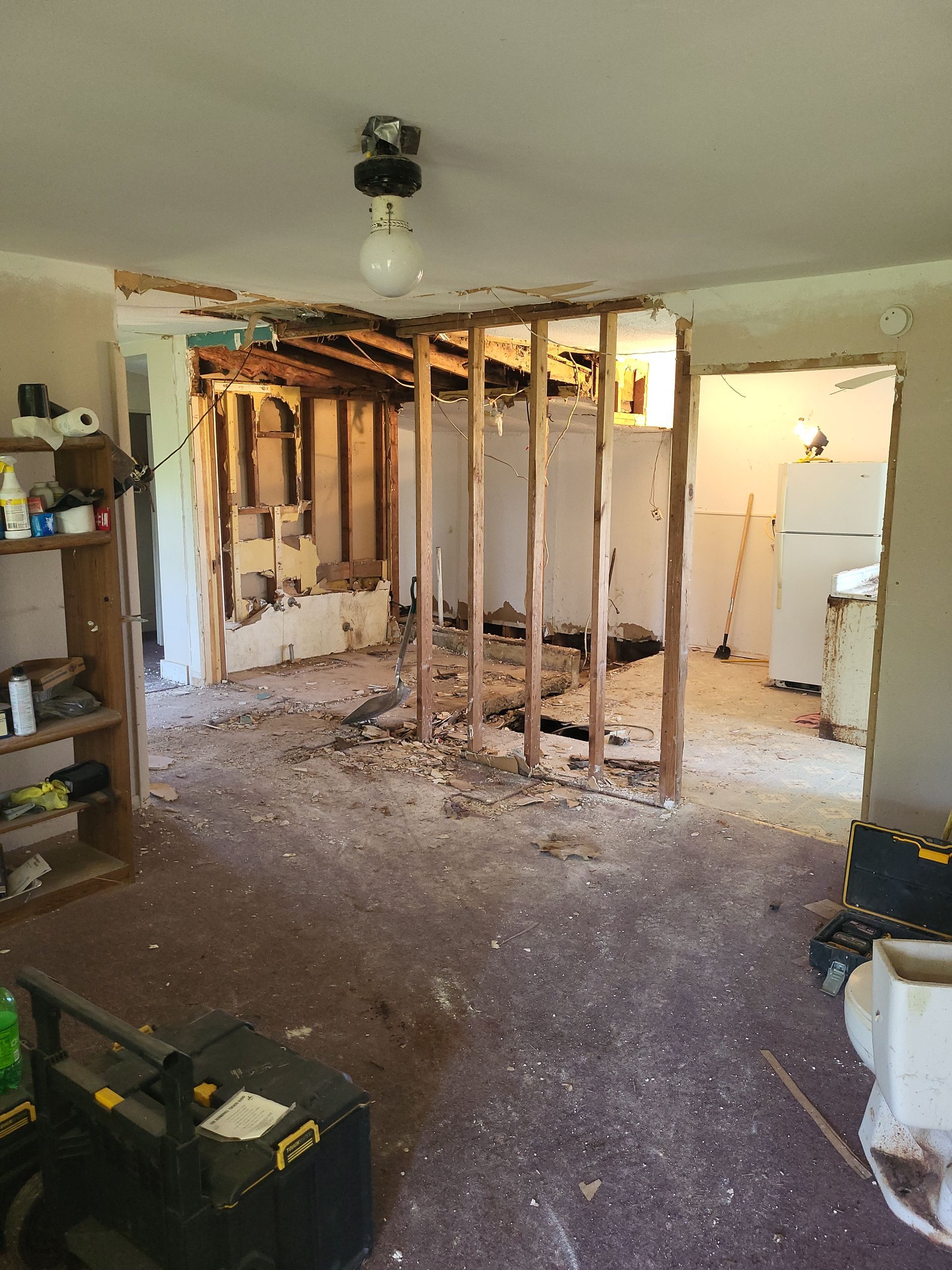A room that is being remodeled with a light on the ceiling.