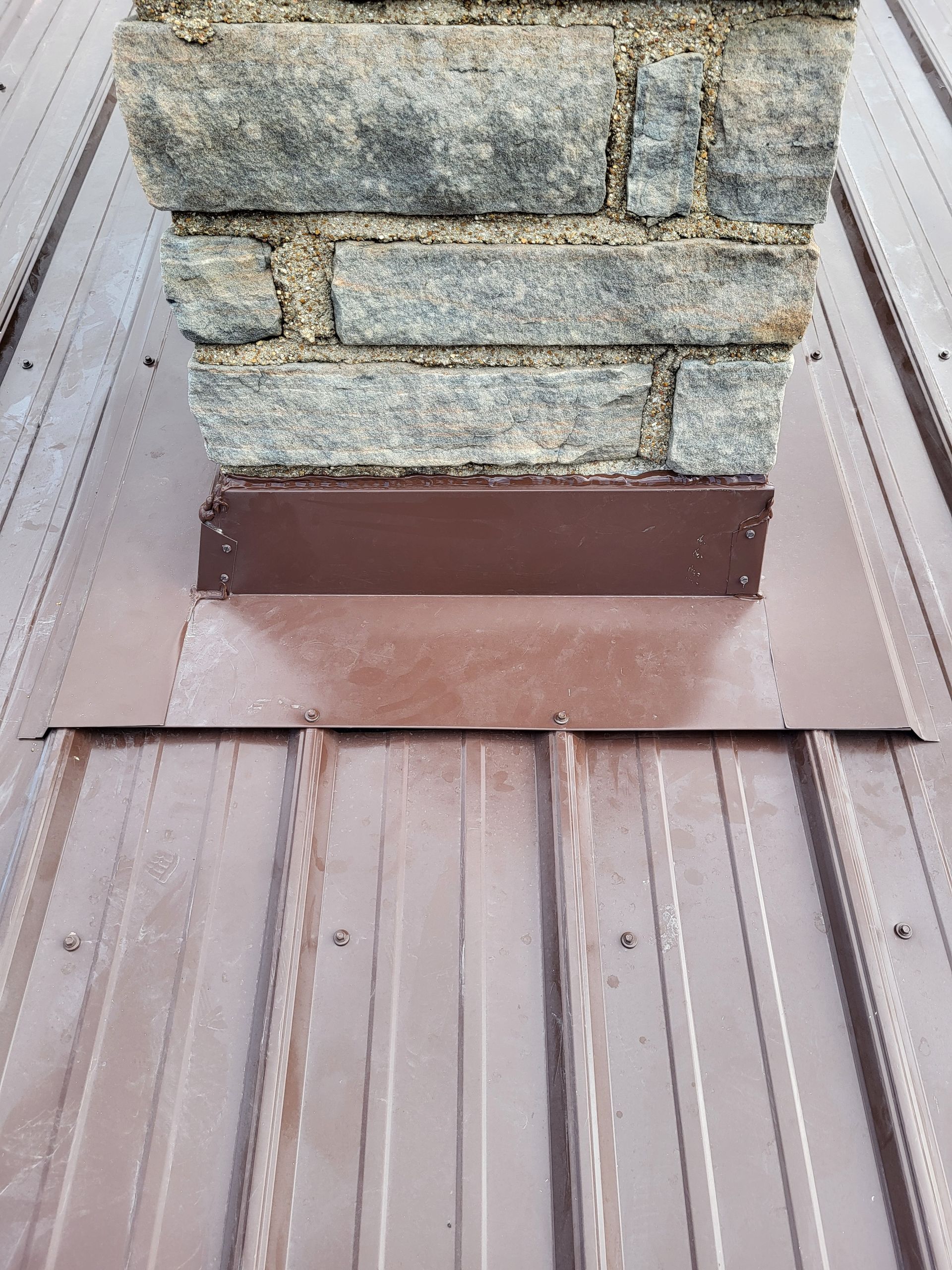 A chimney is sitting on top of a metal roof.
