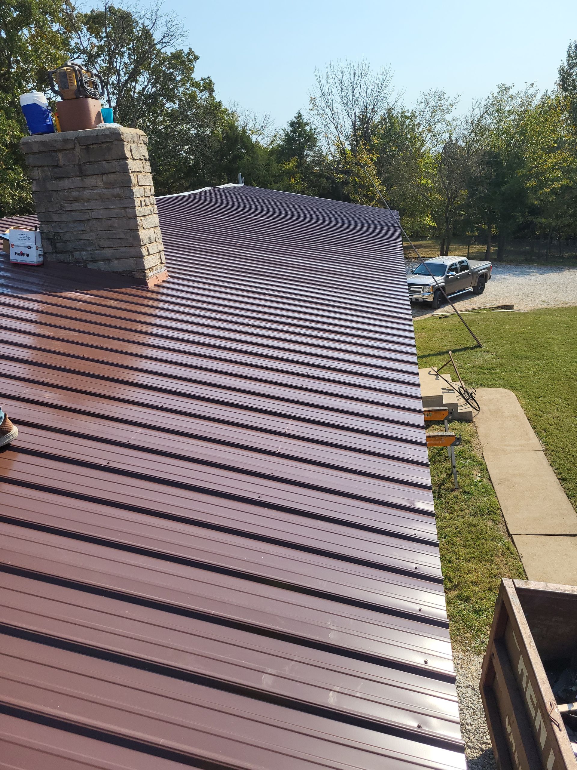 A brown metal roof with a chimney on top of it.
