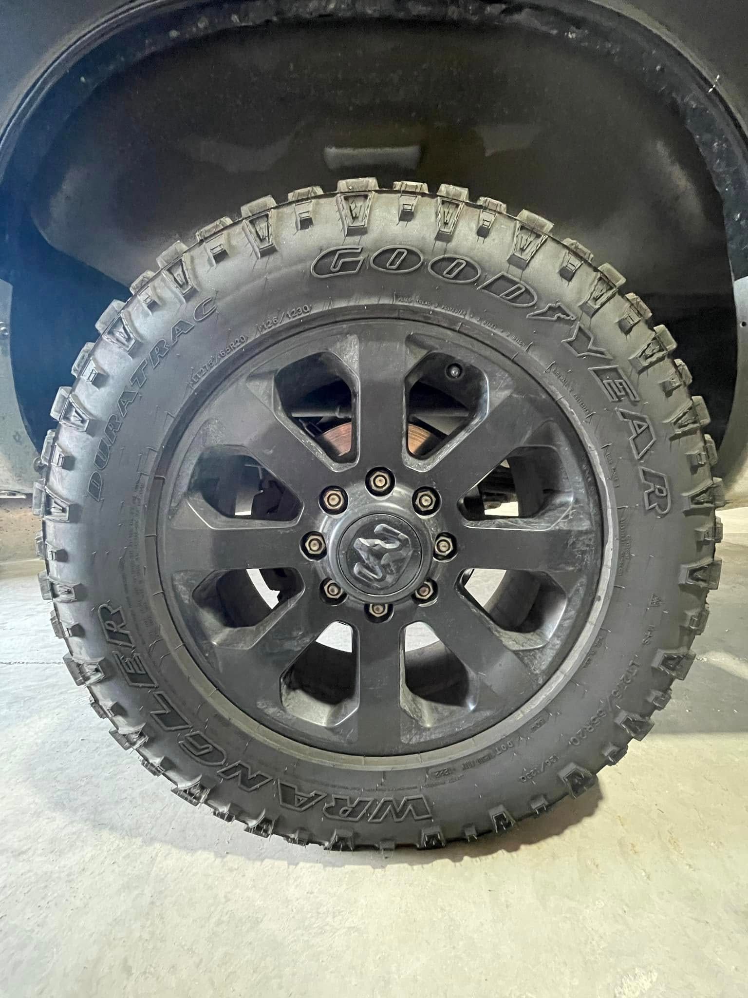 A close up of a black tire on a black truck.