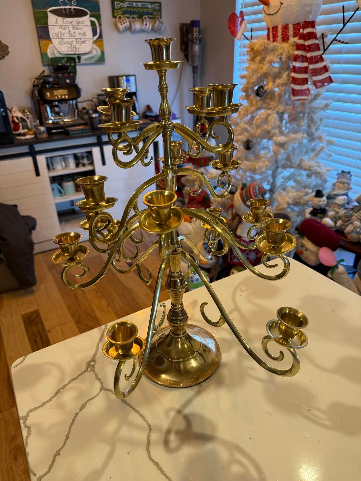 A brass candelabra is sitting on top of a white table in a living room.
