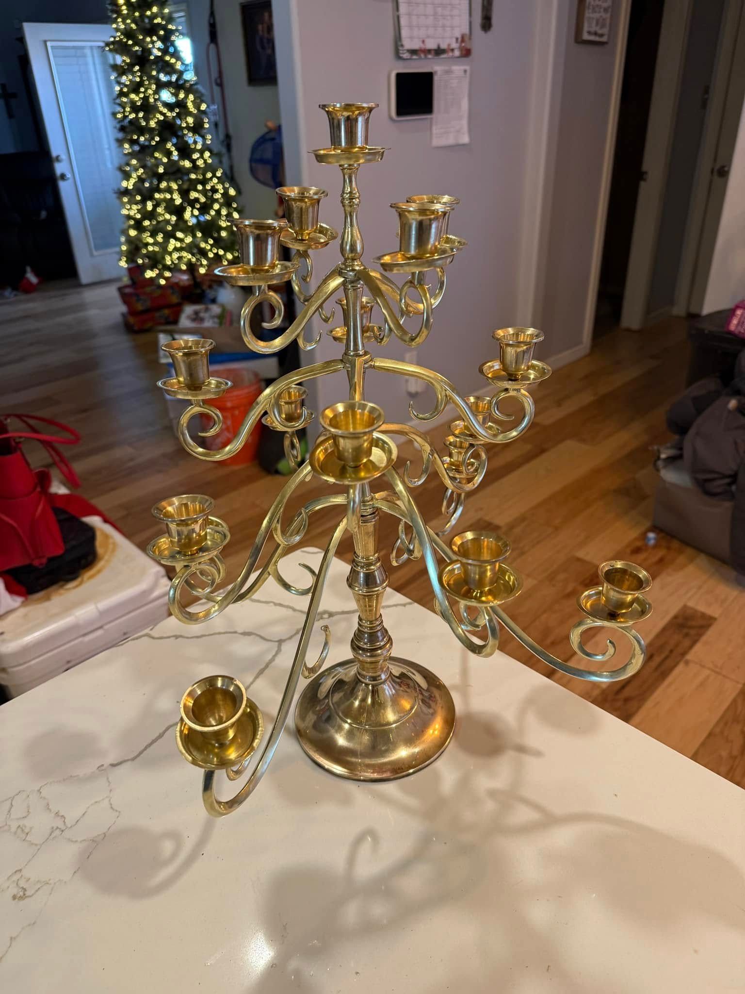 A brass candelabra is sitting on top of a white counter in a living room.