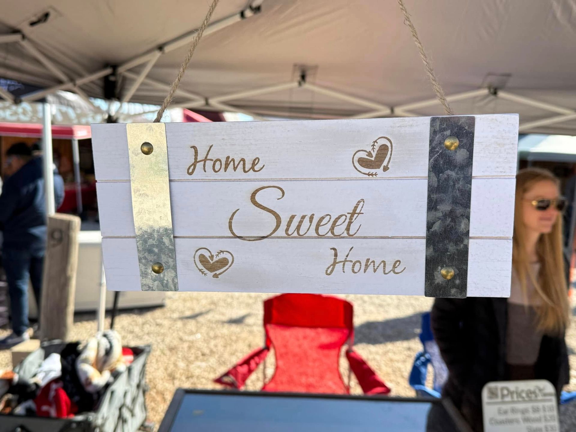 A sign that says home sweet home is hanging from a tent.