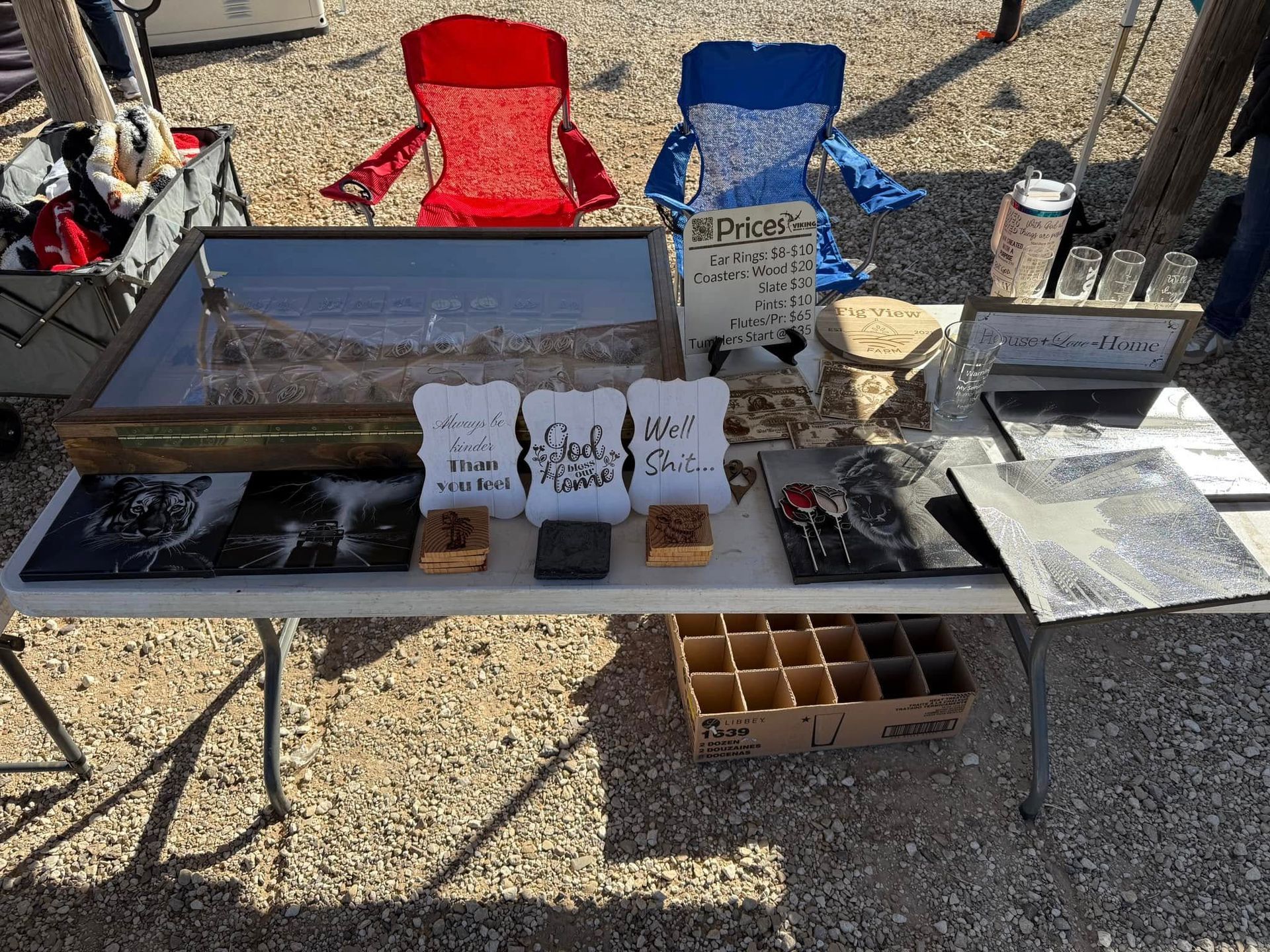 A table with a lot of items on it and two chairs in the background.