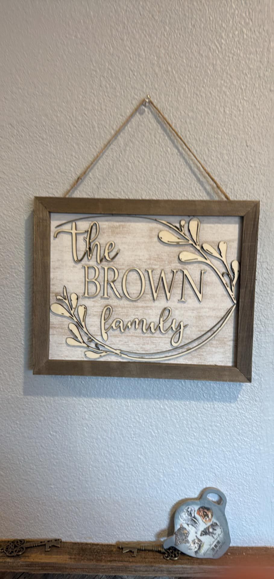 A wooden sign hanging on a wall that says `` the brown family ''.