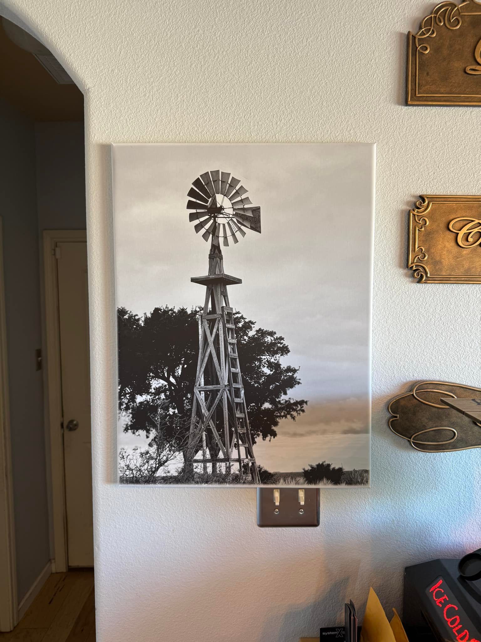 A black and white photo of a windmill on a wall.