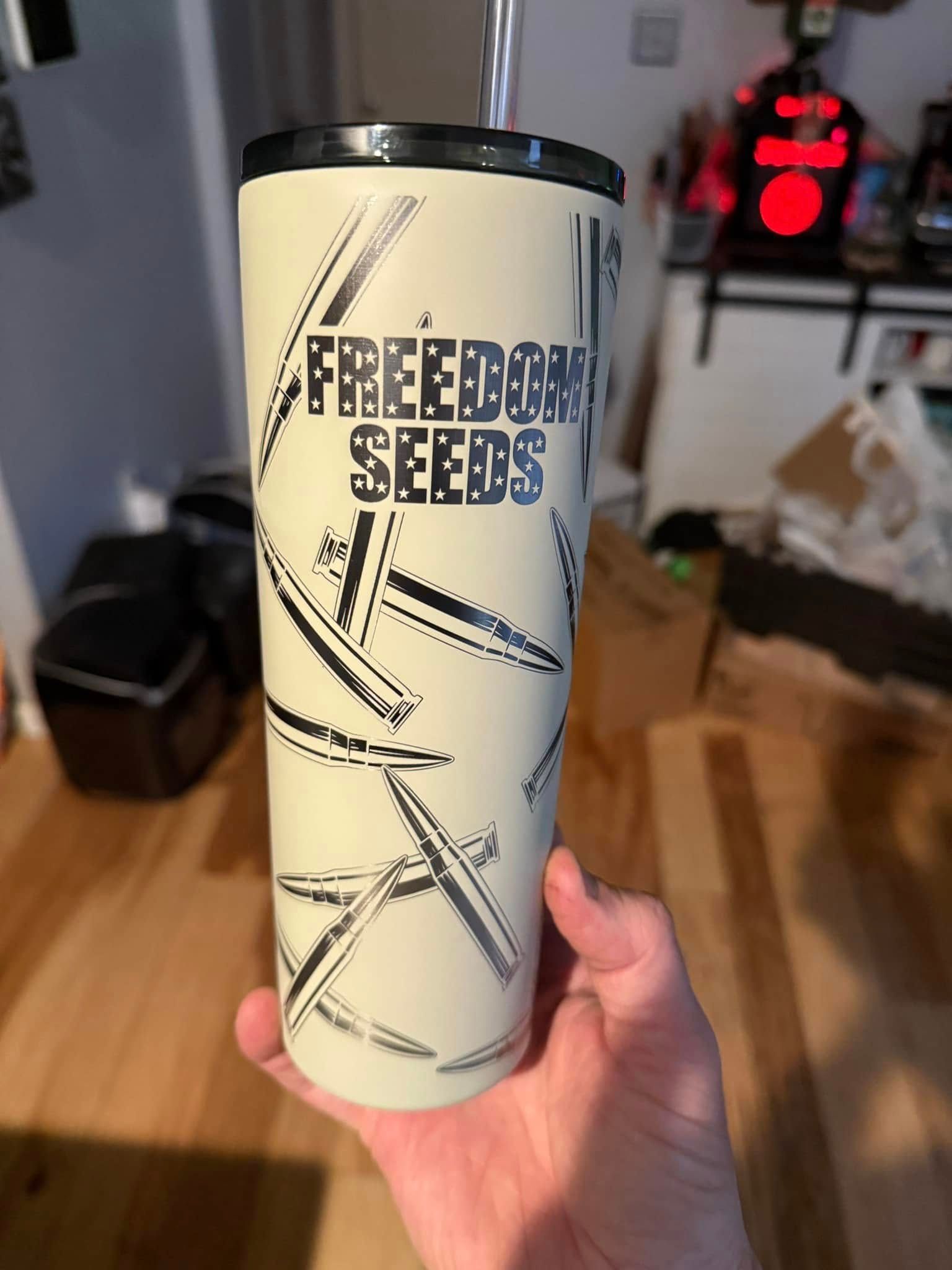 A person is holding a cup that says freedom seeds on it