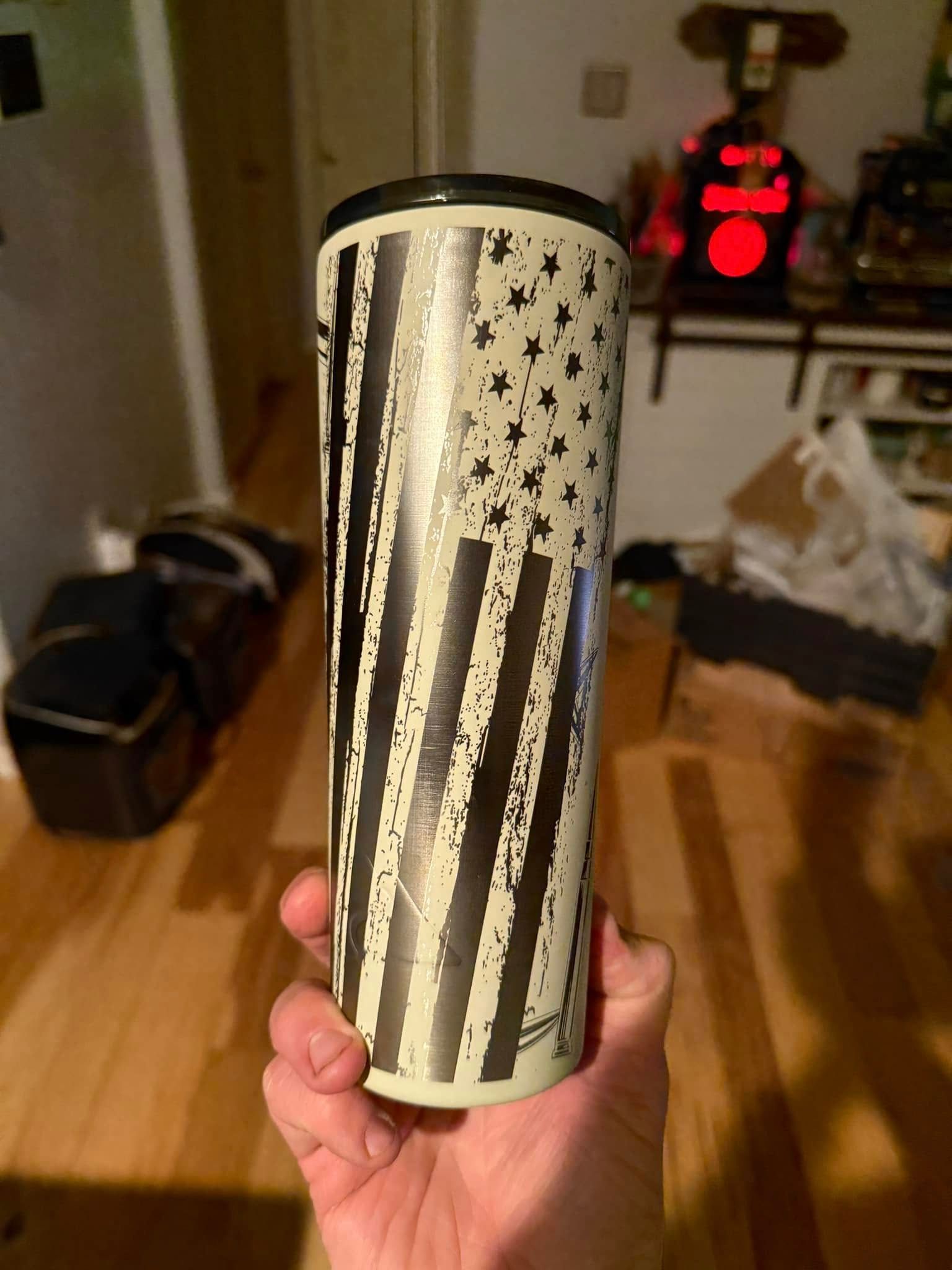 A person is holding a tumbler with an american flag on it.