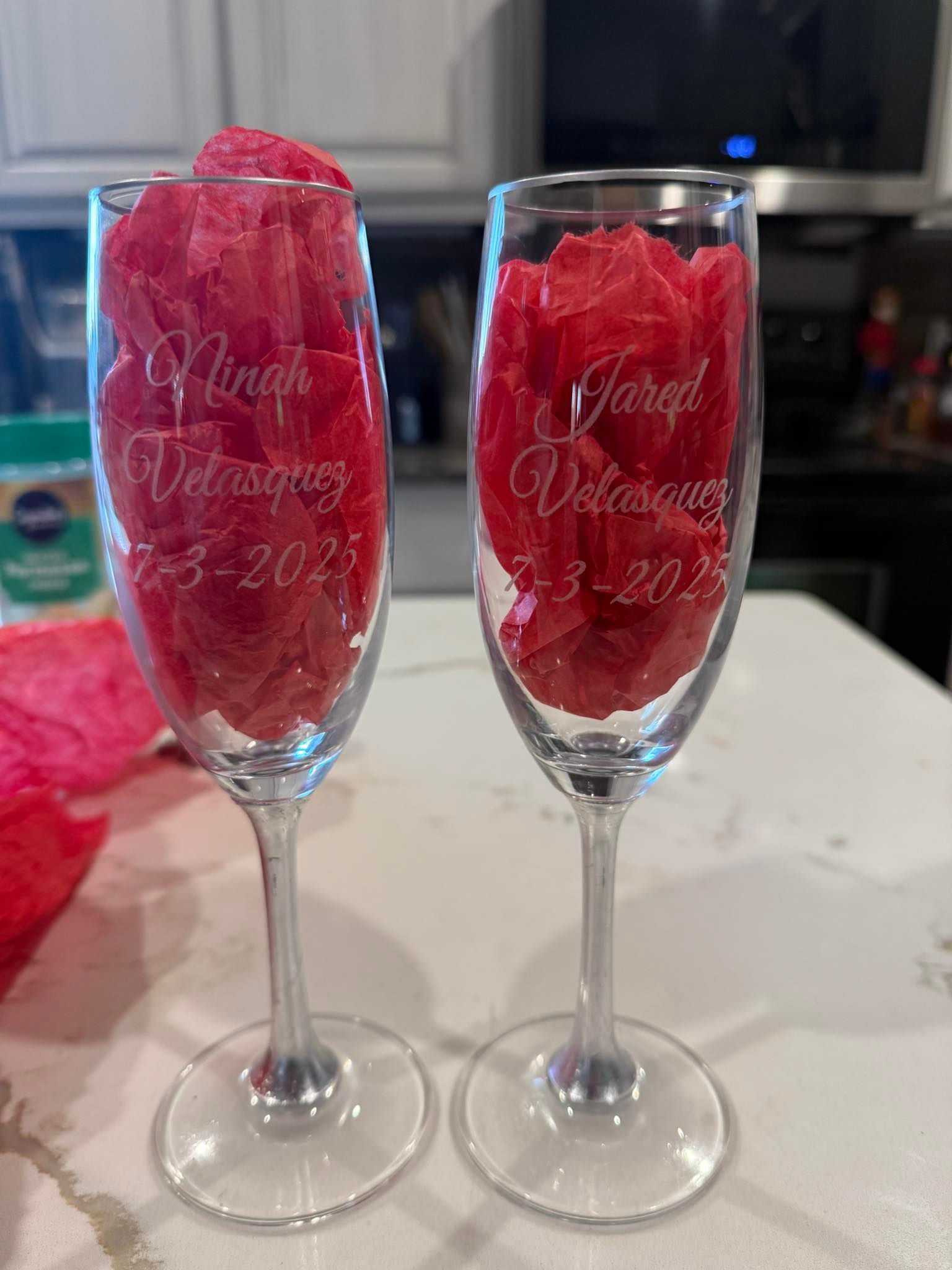 Two champagne flutes filled with watermelon are sitting on a counter.