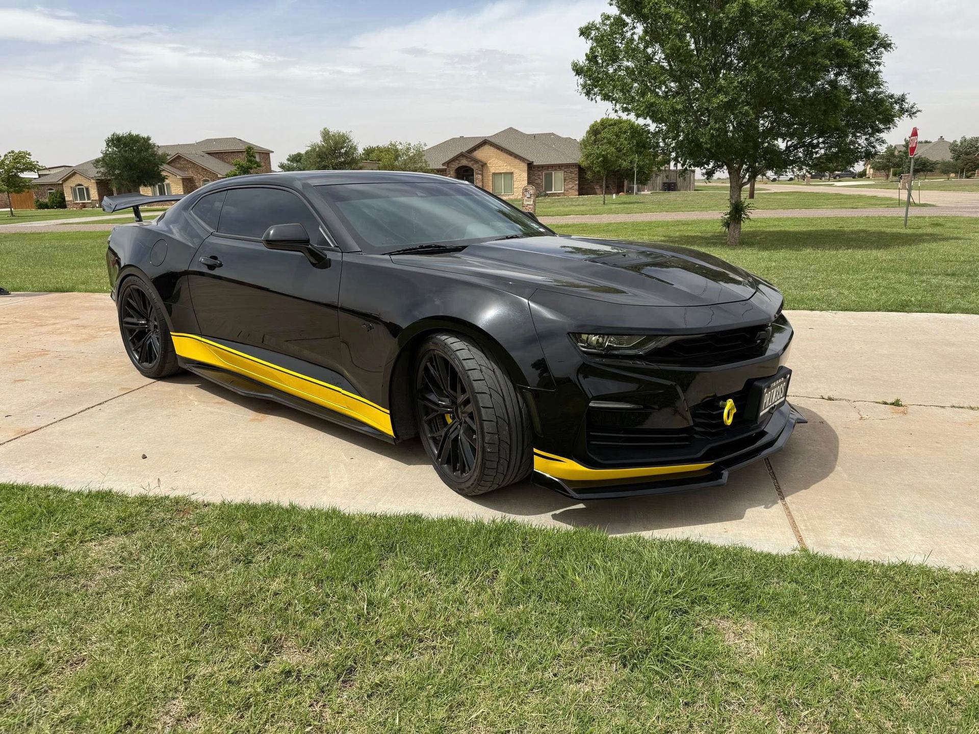A black and yellow sports car is parked on the side of the road.