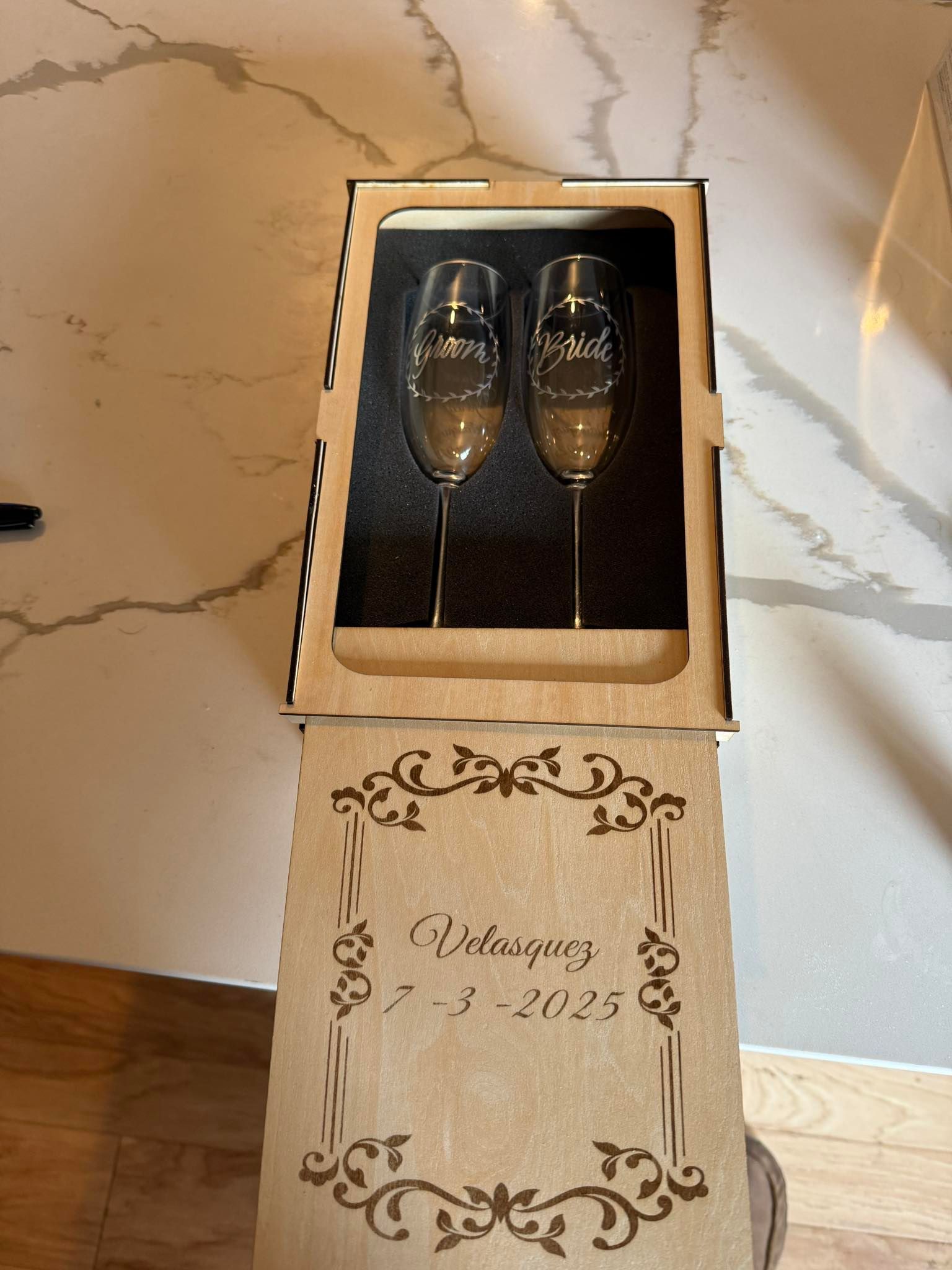 A wooden box with two champagne glasses in it