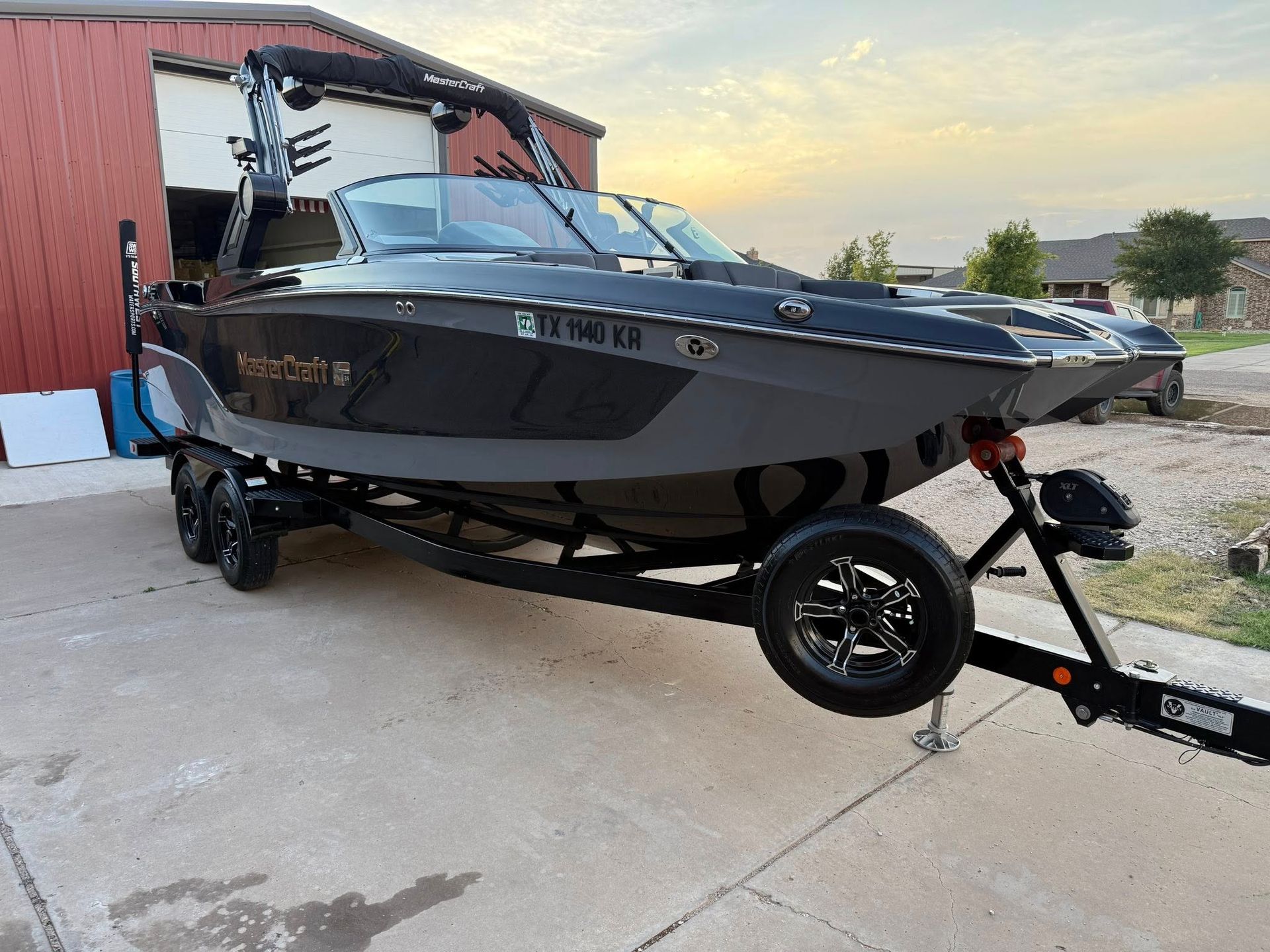 A boat is parked on a trailer in front of a building.