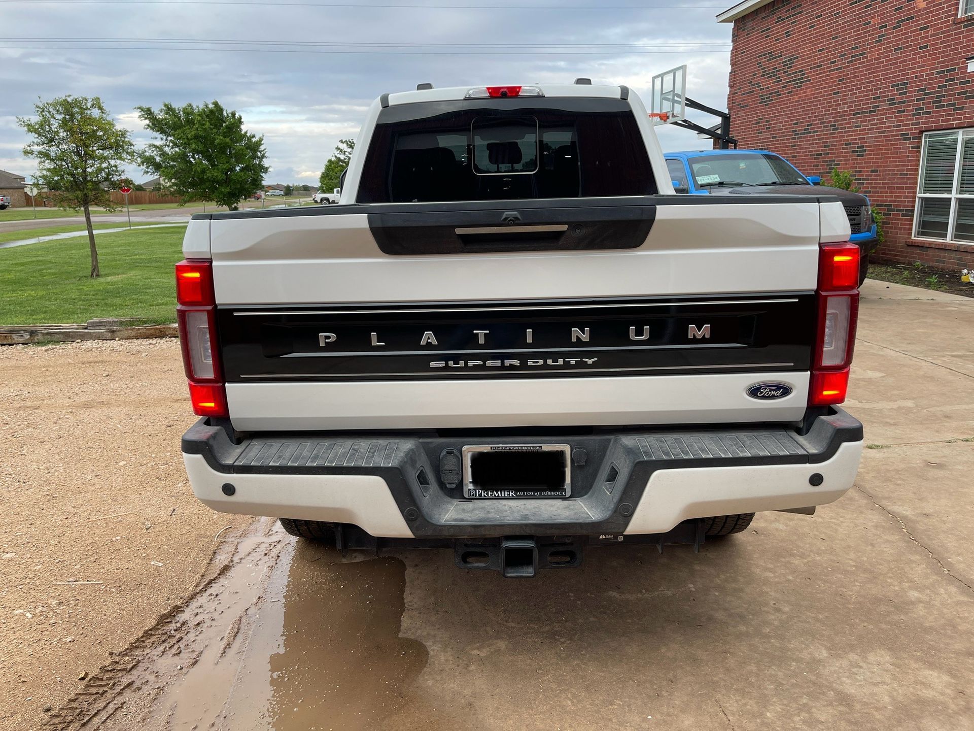 Rear view of a light tan Ford Super Duty Platinum pickup truck. 
