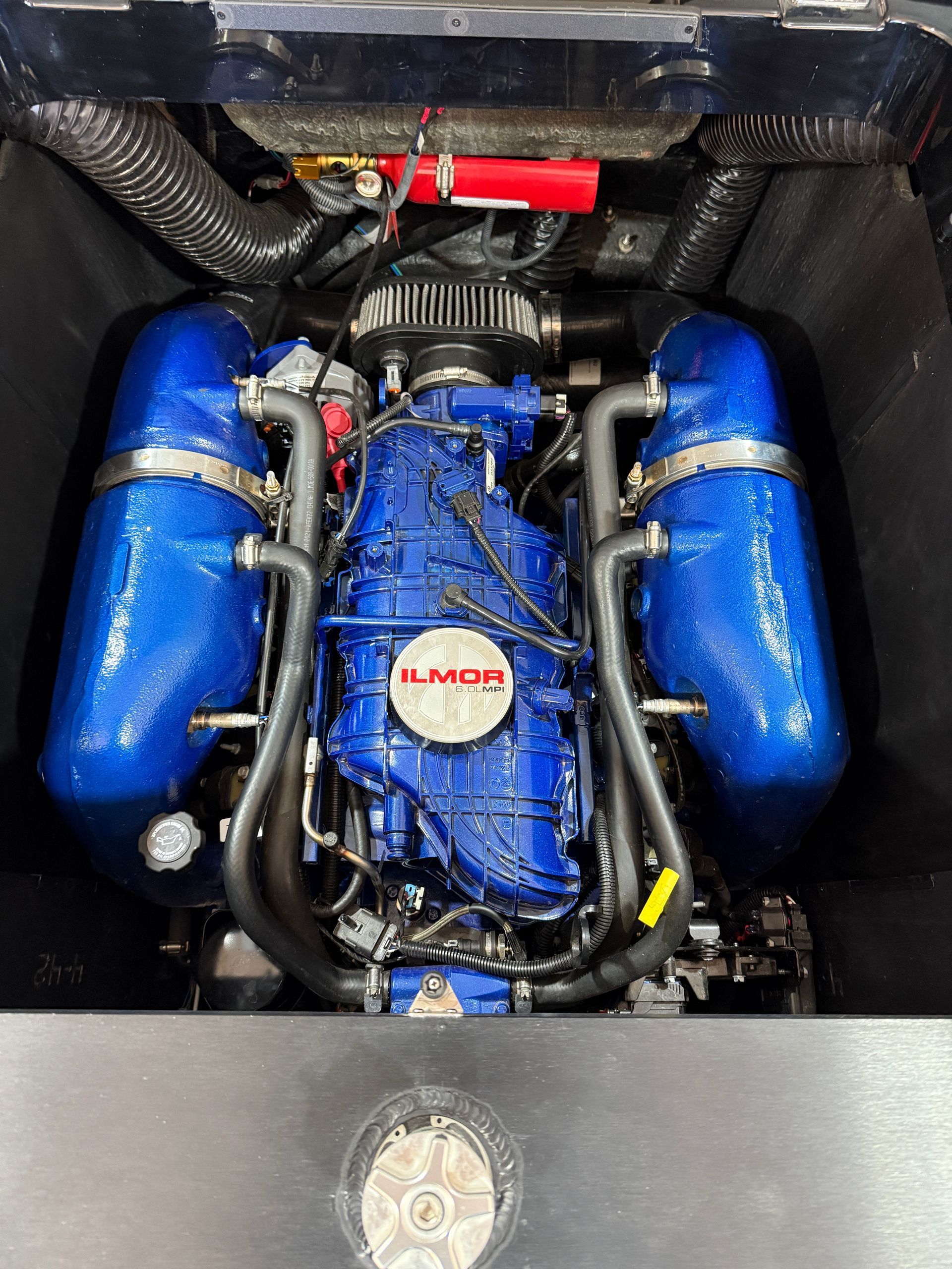 Blue Ilmor boat engine with two large blue canisters, viewed from above. Black hoses and wiring.