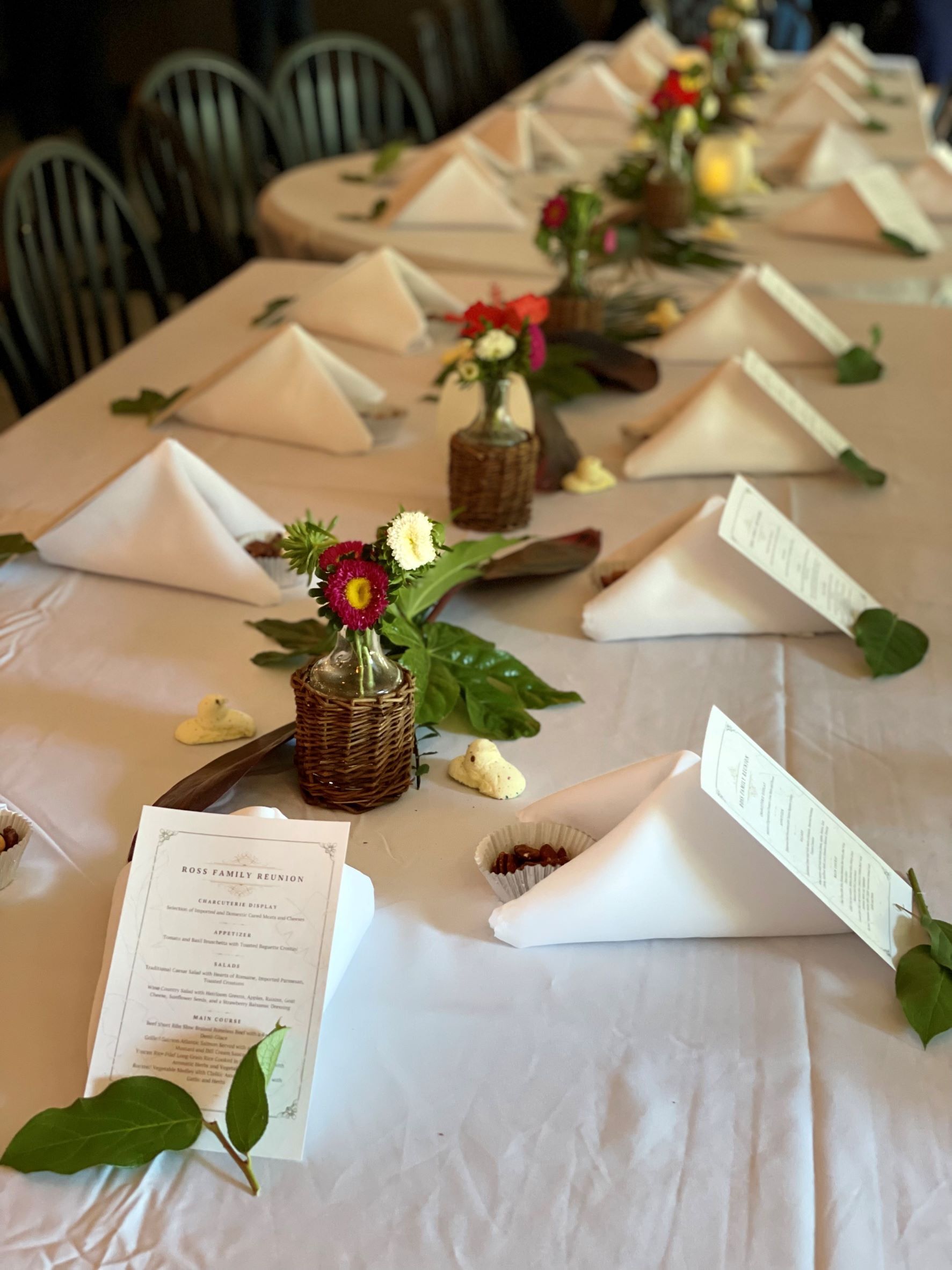 Beautiful flowers and white folded napkins adorn the tables for this rehearsal dinner at The Nook in Temecula, CA