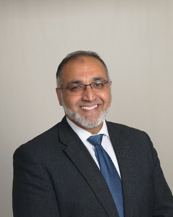 A man in a suit and tie is smiling for the camera.