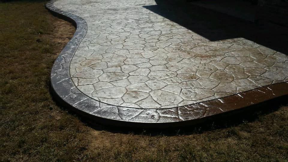 Stamped concrete patio with stone pattern and dark gray border.