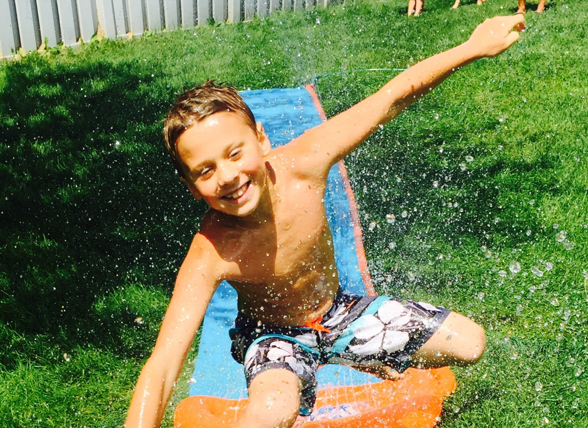Boy on a water slide at Parkettes Camp