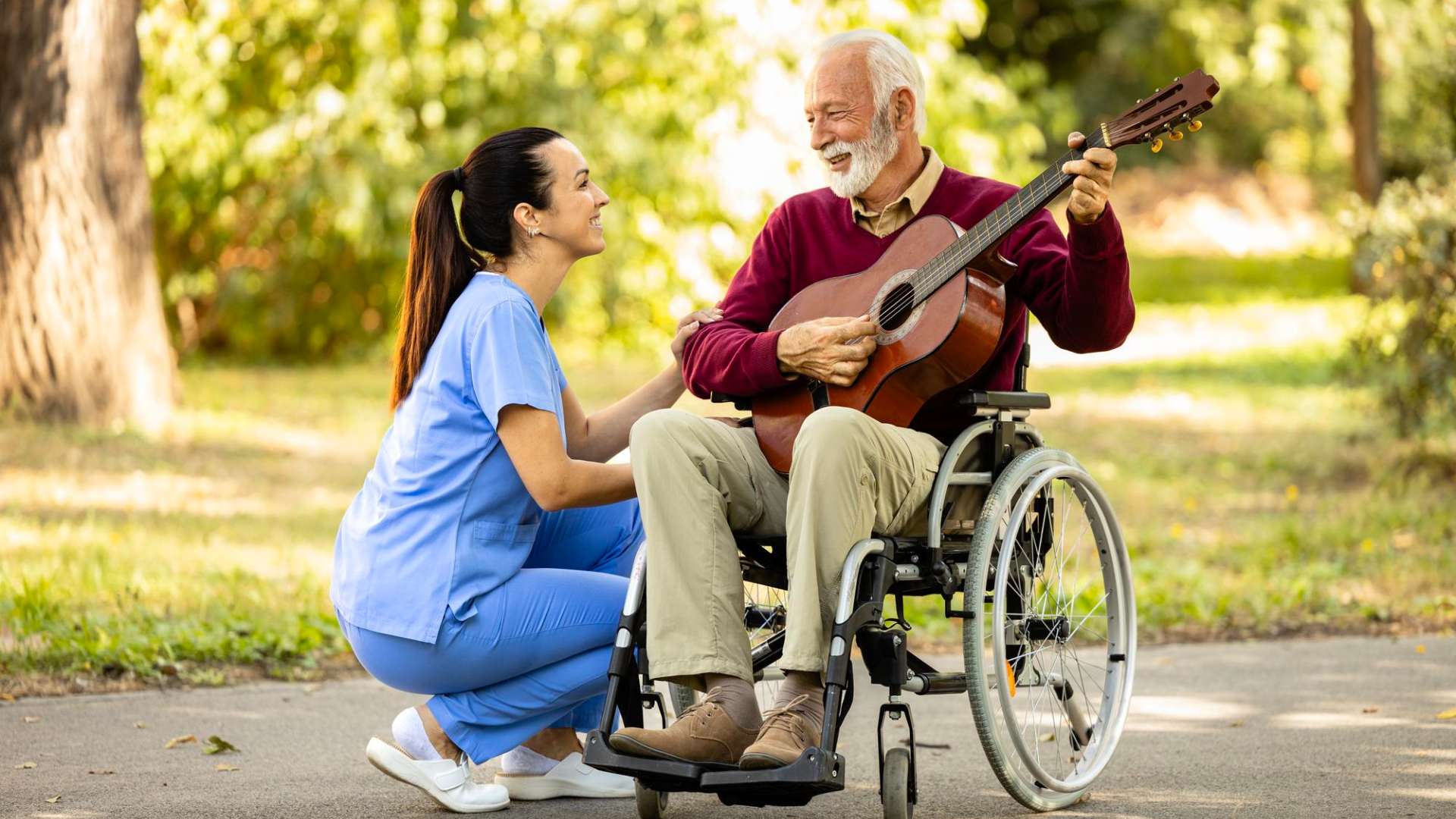 disabled older person in wheelchair with guitar with care staff