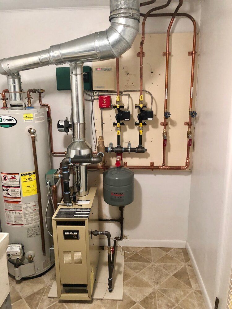 A room with a water heater , boiler , and pipes.