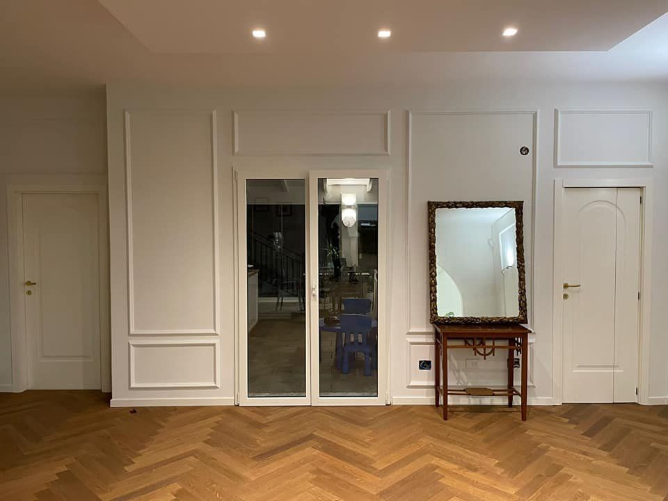 Stanza con arredamento bianco e specchio in legno