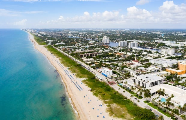 An aerial view of a beach with a city in the background.