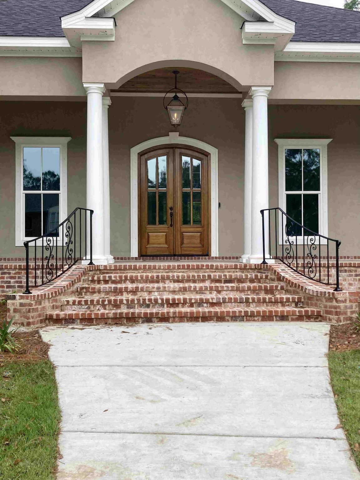 A house with a brick walkway leading to the front door