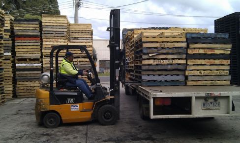 Man in front of used pallets in Melbourne