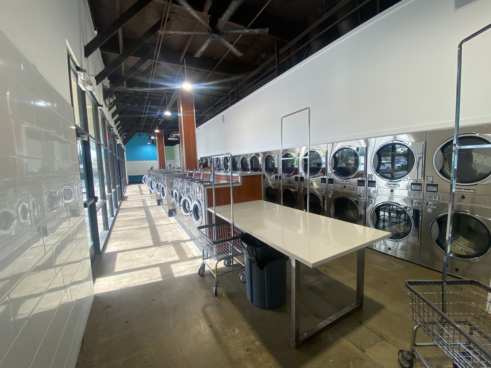 a laundromat with a lot of washing machines and a table . | Fresno, CA | ALCO Services