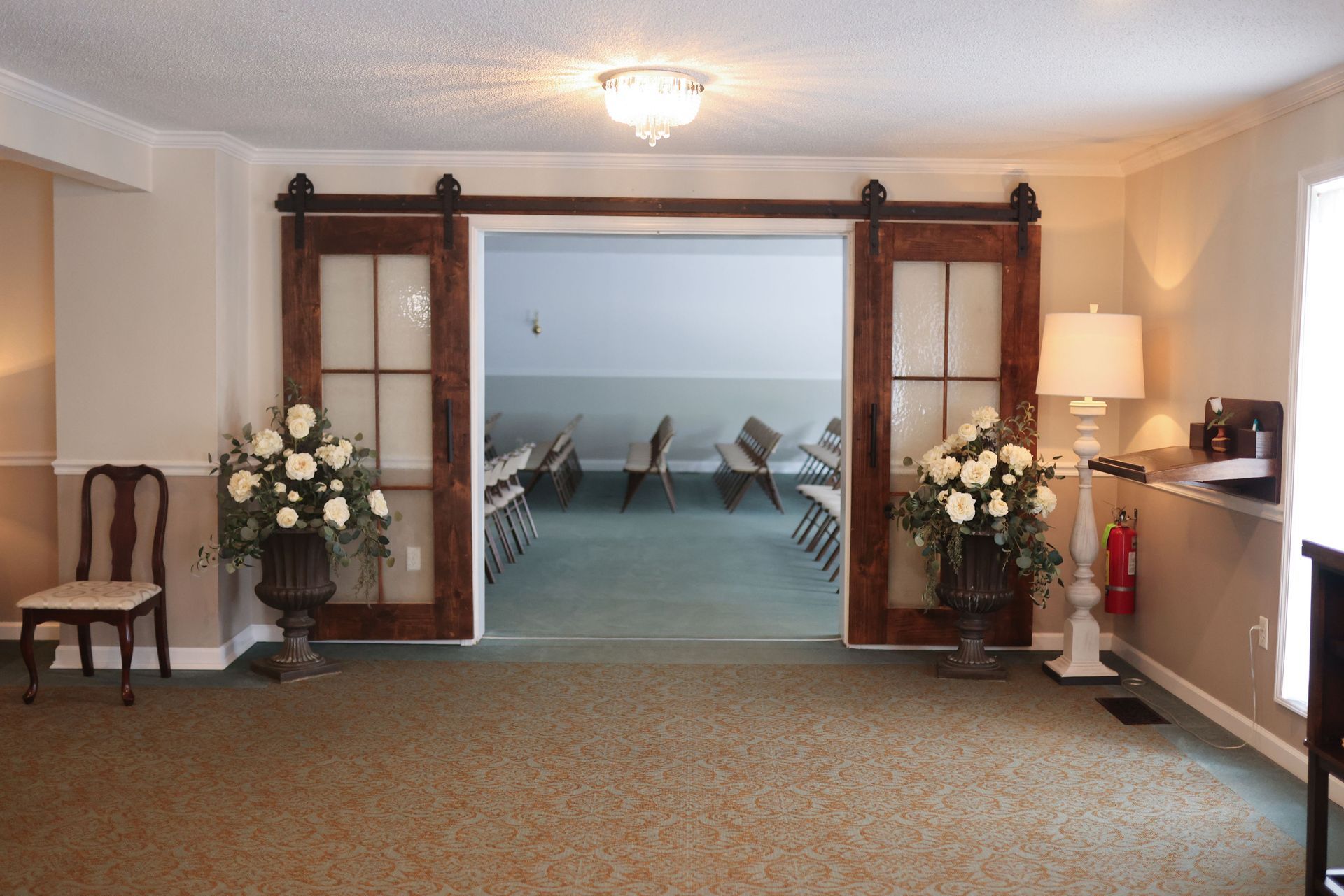 A room with sliding barn doors and flowers in vases