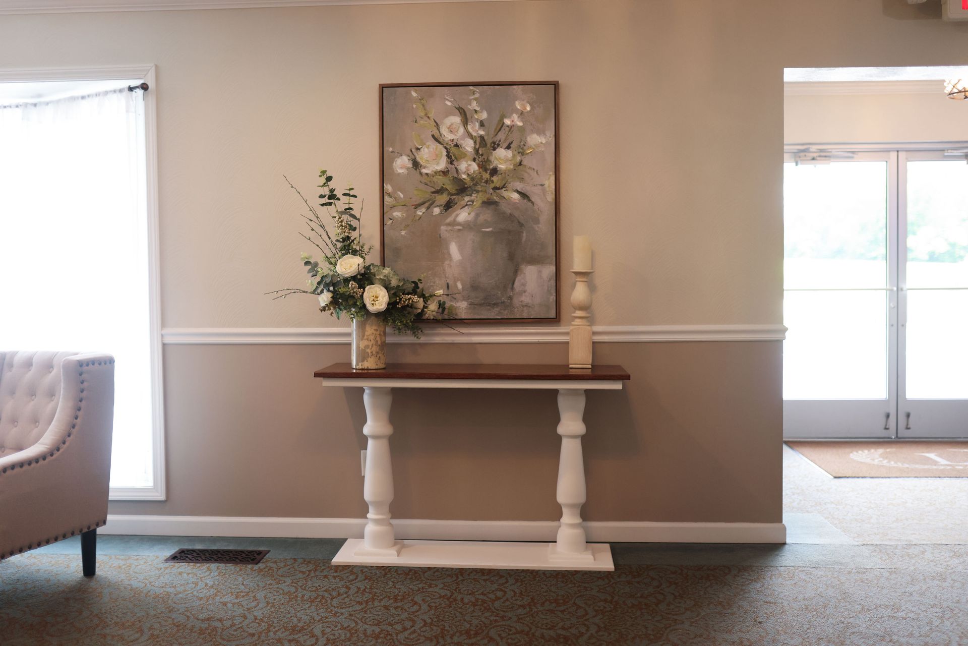 There is a table with flowers on it in the middle of the room.