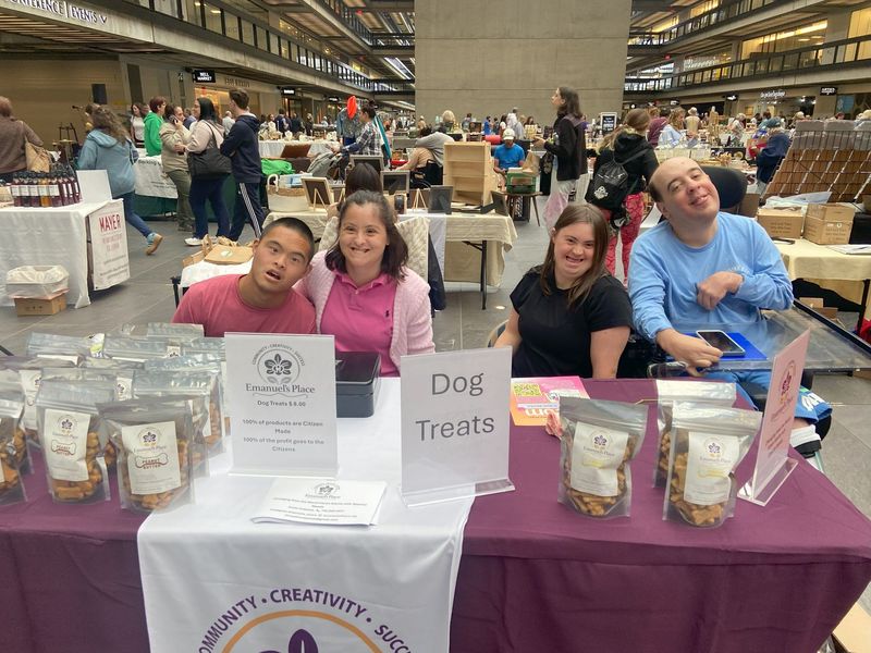 A group of people wearing aprons are posing for a picture in front of a building.