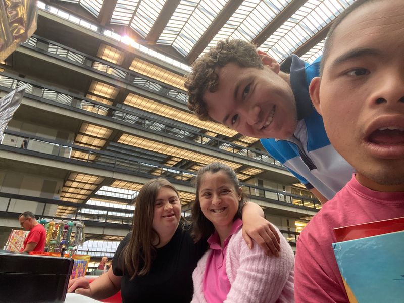 A man is kneading dough in a kitchen with blue cabinets.
