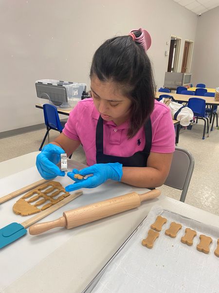 A man wearing glasses and a hat is holding two bowls in his hands.