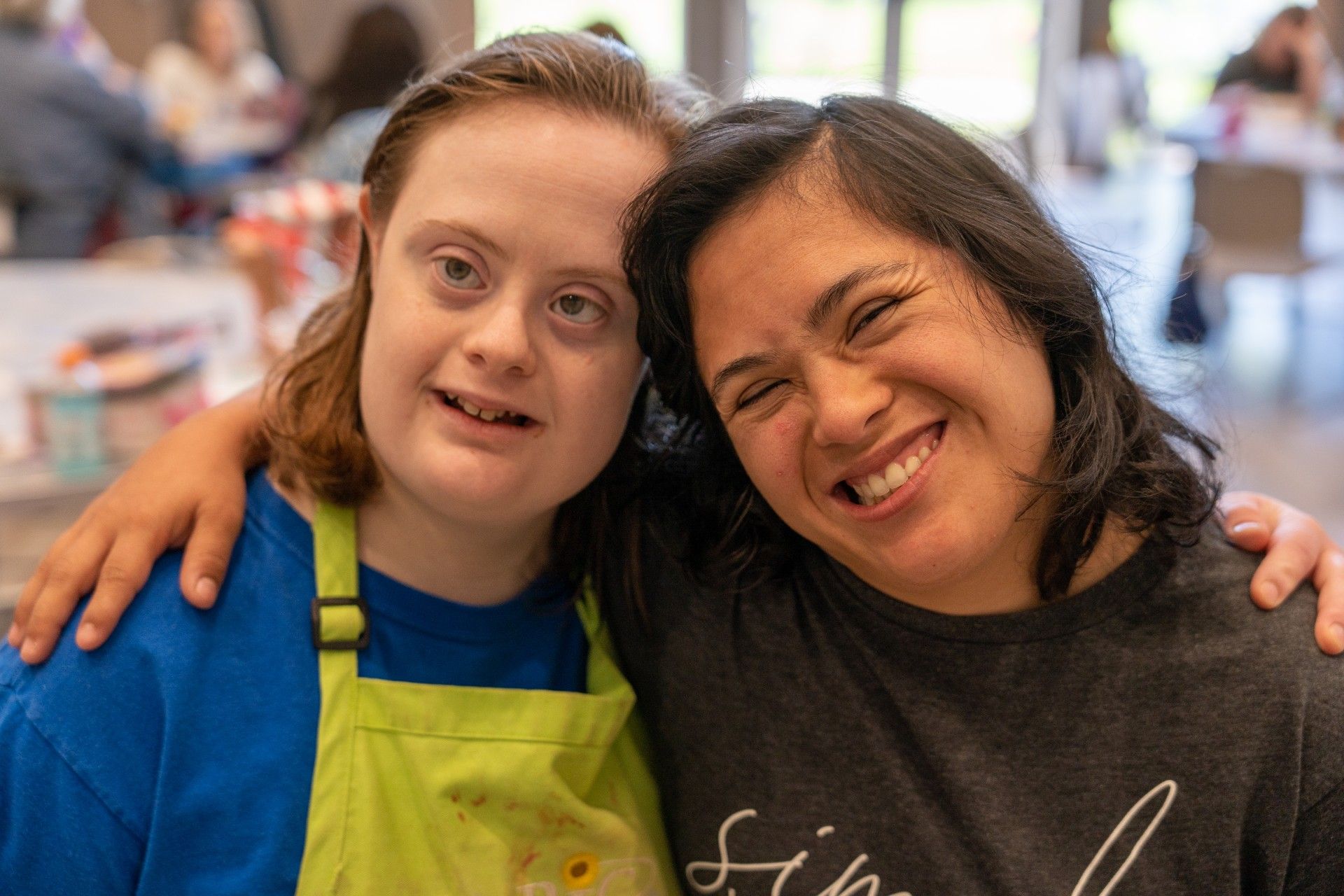 Two women are posing for a picture together and smiling for the camera.