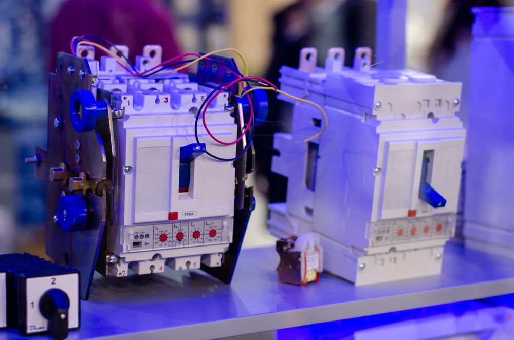 Circuit breakers with levers and wires, on a table.