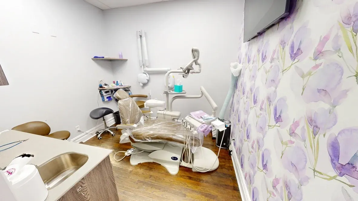A dental office with a purple wall and a dental chair.