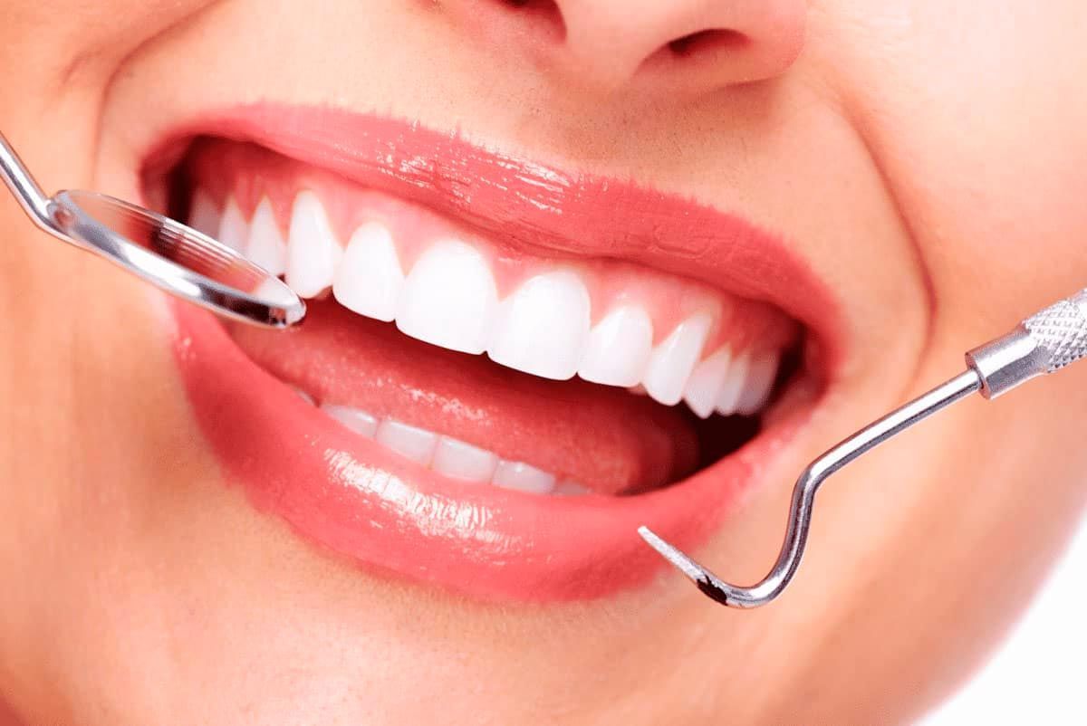 A woman is getting her teeth examined by a dentist.
