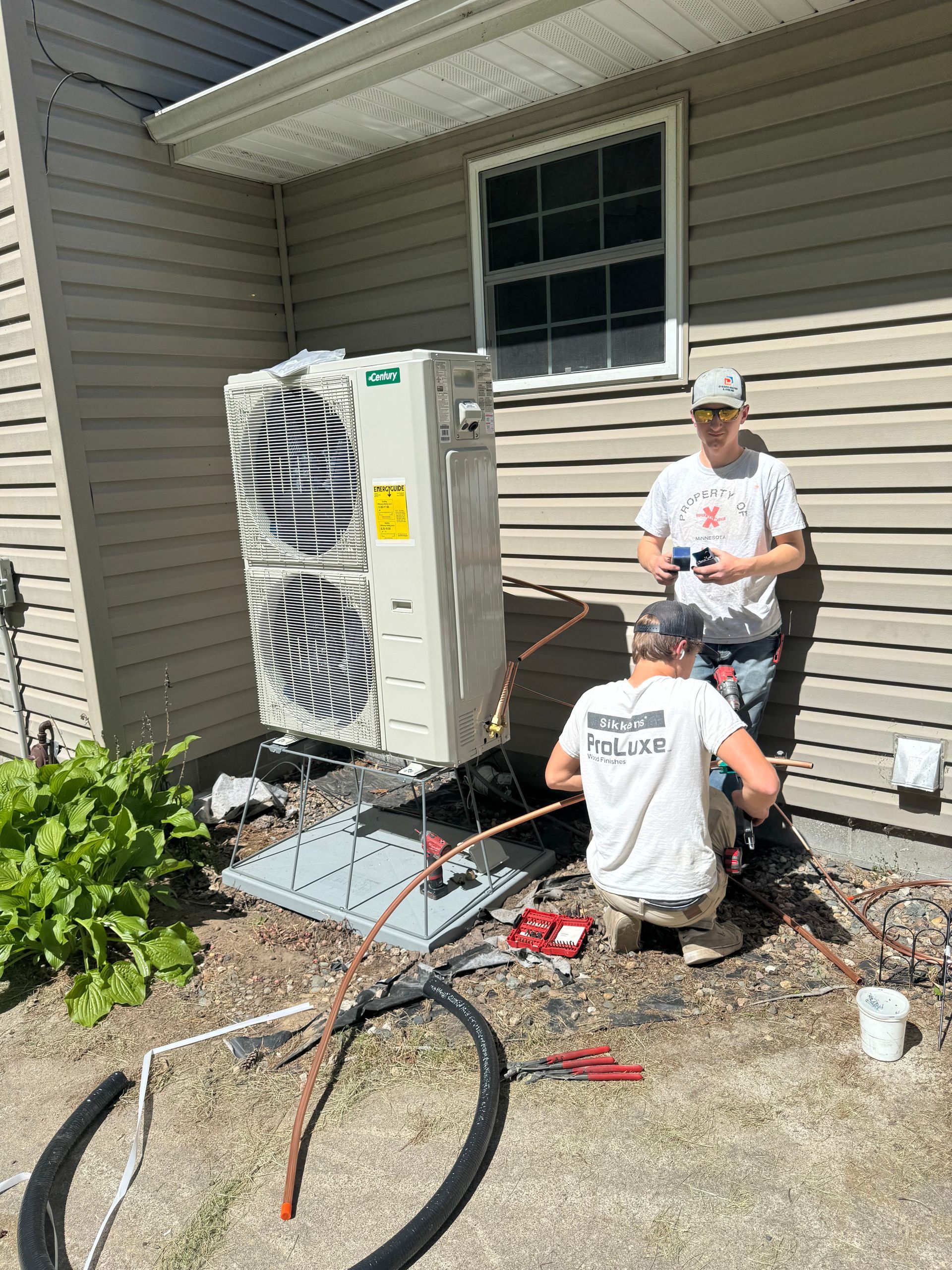 A man is working on an air conditioner on a roof.