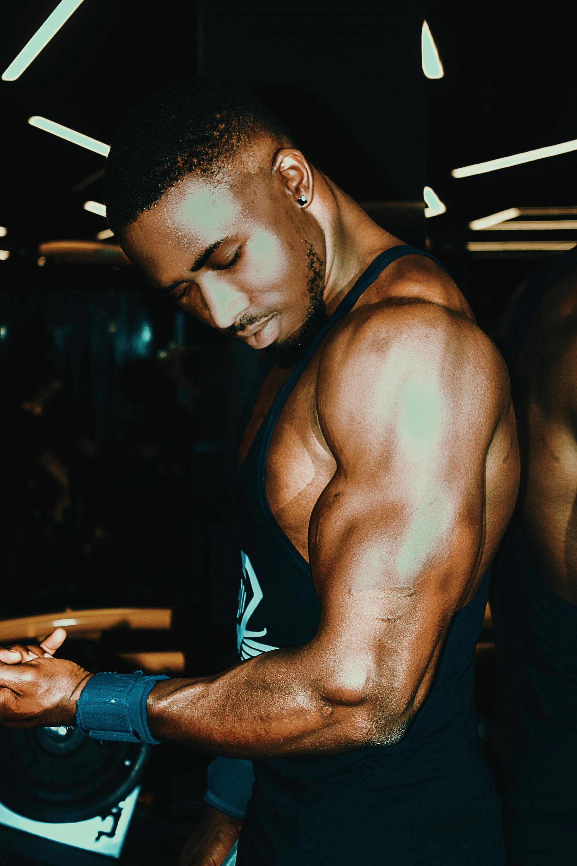 A man is flexing his muscles in a gym.